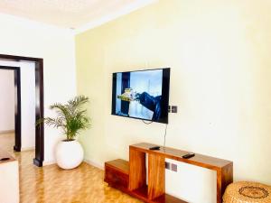 カンパラにあるMarama Staysの壁にテレビが取り付けられたリビングルーム