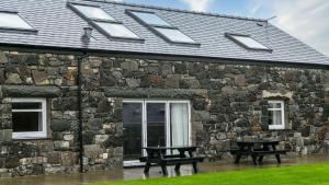 two benches in front of a stone building at Llydaw in Pwllheli
