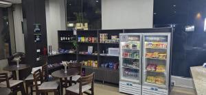 a restaurant with a refrigerator and tables and chairs at Samba Três Lagoas in Três Lagoas