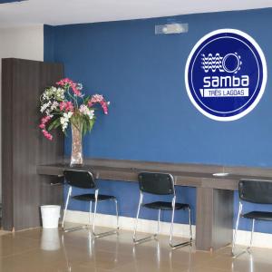 a table with chairs and a vase with flowers at Samba Três Lagoas in Três Lagoas