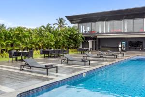 a resort with a swimming pool and tables and chairs at Crystal Village in Nagoa-Bardez