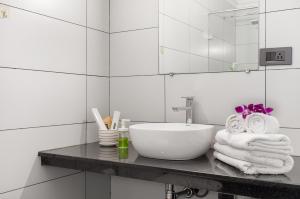 a bathroom with a sink and a mirror and towels at Crystal Village in Nagoa-Bardez +44 photos