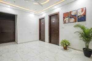 a hallway with doors and plants in a building at Fabhotel JP Villa - Nr Stadium in Varanasi