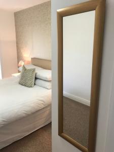 a mirror on a wall next to a bed at The Downtown Loft in Buncrana