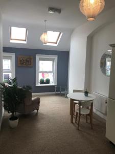 a living room with a table and a chair at The Downtown Loft in Buncrana
