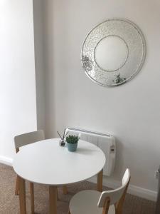 a white table with chairs and a mirror on the wall at The Downtown Loft in Buncrana