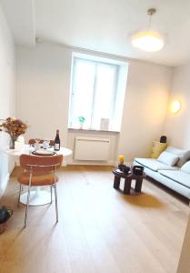 een woonkamer met een tafel en een bank bij Le Ptit Rennes- 200 m de la Gare Cosy Lumineux in Rennes +6 foto's