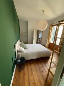 Un dormitorio con una cama grande y una pared verde. en QuarantaVasi, en Rávena