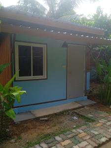 a small house with a blue wall and a window at Bang risskee home stay1 in Ko Yao Noi +2 photos