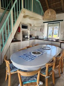 a kitchen with a large white table and chairs at Hannah's Close in Struisbaai +16 photos