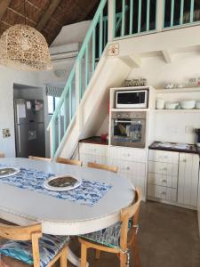 a kitchen with a table and chairs and stairs at Hannah's Close in Struisbaai