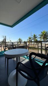 a table and chairs on a balcony with a view of the beach at Santa Helena Pousada in Guarujá