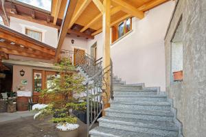 a stone staircase in a house with wooden ceilings at Agriturismo Quinto Quarto in Sondalo