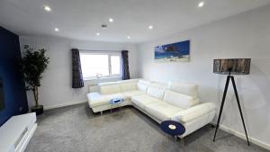 a living room with a white couch and a window at Stepping Stones in Perranporth