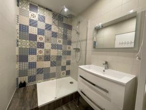 ein Badezimmer mit Waschbecken, Dusche und Spiegel in der Unterkunft Les Gîtes de l'ile à Metz in Metz + 39 Fotos