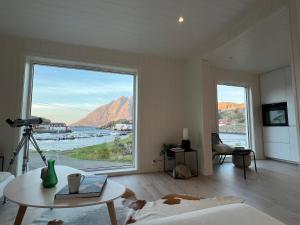 a living room with a large window with a view at Aurora Bay Villa Lofoten in Sund