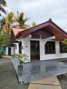 a small house with a courtyard in front of it at Ryo hostel in Ahangama