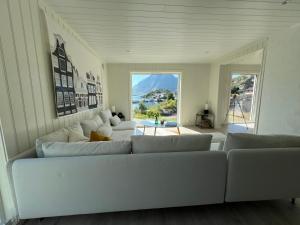 a living room with a white couch and a large window at Aurora Bay Villa Lofoten in Sund
