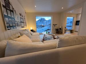a living room with a large couch and a table at Aurora Bay Villa Lofoten in Sund +126 photos