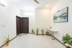 a white room with a door and plants at FabHotel Golf Luxury- 10 Min From Sector 42-43 Rapid Metro Station in Gurgaon