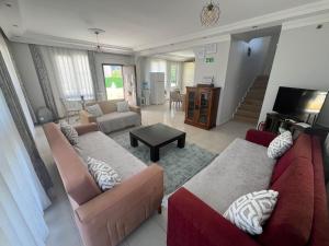 a living room with two couches and a television at ALTINKUMDA 12 Kişilik ÖZEL HAVUZLU VİLLA in Didim