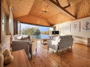 een woonkamer met banken en uitzicht op het water bij The Boathouse - Uk50892 in Pentney