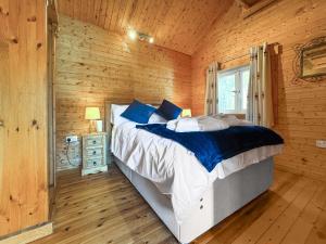 een slaapkamer met een bed in een houten hut bij The Boathouse - Uk50892 in Pentney +9 foto's