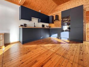 een keuken met zwarte kasten en een houten vloer bij The Boathouse - Uk50892 in Pentney