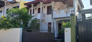 安伯朗戈德Ambalangoda Villa 3的一座白色的房子，前面有大门