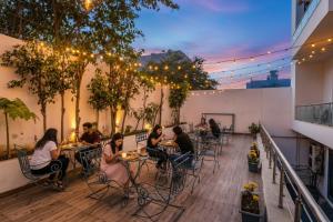 Un grupo de personas sentadas en mesas en un patio. en FabHotel Golf Luxury, en Gurgaon