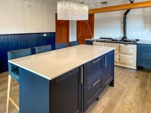 Una cocina con gabinetes azules y una encimera. en Abalone, en Culbokie