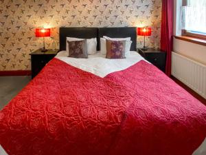 1 dormitorio con 1 cama roja y 2 lámparas en Abalone, en Culbokie 9 fotos más
