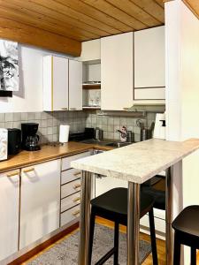 een keuken met witte kasten en een marmeren aanrecht bij Traditional Lapland Studio Peaceful and Simple in Rovaniemi