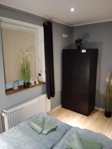 a bedroom with a bed and a cabinet and a window at Stadtnah an der Förde 5705 in Flensburg