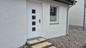 a white door of a white house with a window at Stadtnah an der Förde 5705 in Flensburg