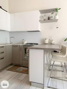 a kitchen with white cabinets and a counter top at Paty's House Milano in Milan