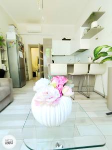 a vase with flowers on a glass table in a room at Paty's House Milano in Milan +3 photos