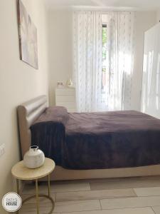 a bedroom with a bed and a table and a window at Paty's House Milano in Milan