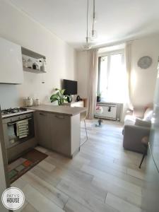 a kitchen and living room with a stove and a couch at Paty's House Milano in Milan