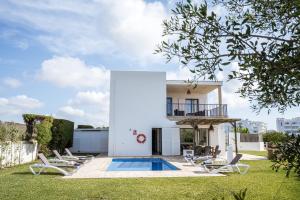 a villa with a swimming pool in front of a house at Ca na Magdalena in Cala d´Or