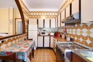 松达洛Appartamento Alice的厨房配有2张桌子和台面