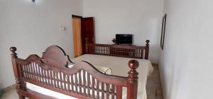 安伯朗戈德Ambalangoda Villa 3的带电视的客房内的木床