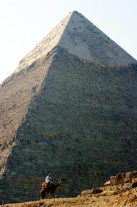 a man riding a camel in front of a pyramid at Grand Delta Hotel in Cairo