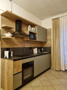 una cucina con mobili in legno e un forno a piano cottura di Appartamento a Monclassico a Monclassico