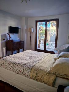 Un dormitorio con una cama grande y una ventana. en Daphne Experience - Fuga Romantica - Giardino Privato - WIFI, en Loreto Aprutino