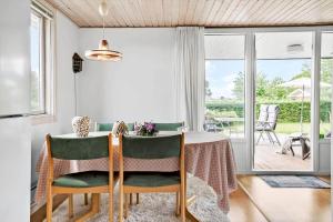 una sala da pranzo con tavolo e sedie verdi di 30493-Odder-Snekkeager-21 a Odder