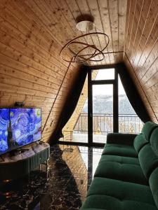 salon z kanapą i dużym oknem w obiekcie Romulus A-Frame w mieście Greşu +18 zdjęć