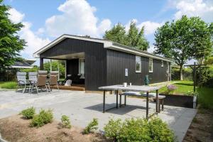 una casa nera con un tavolo davanti di 30493-Odder-Snekkeager-21 a Odder