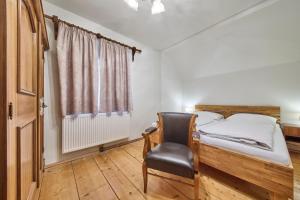 a bedroom with a bed and a chair and a window at Haus Erni in Bad Aussee +34 photos