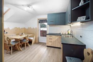 a kitchen with a table and a dining room at Appartamento Primavera 3 in Moena